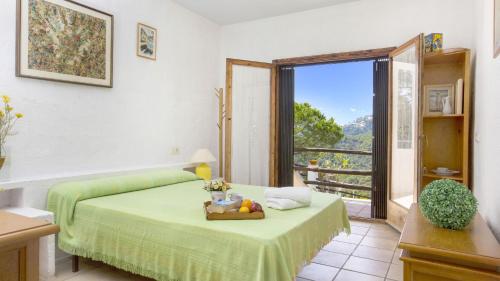 een slaapkamer met een groen bed en een balkon bij 2ibi - Lloret de mar in Lloret de Mar