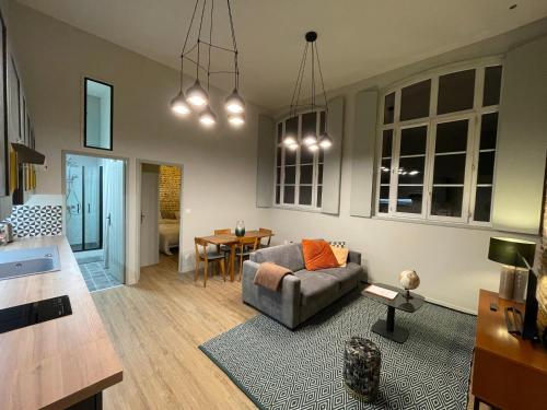 a living room with a couch and a table at "C'est la Récré" Place de parking privative Centre ville in Dieppe