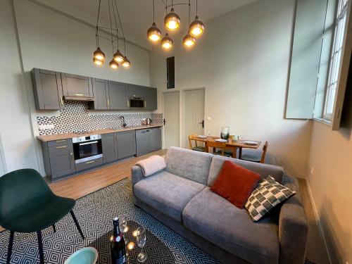 Il comprend un salon avec un canapé et une cuisine. dans l'établissement "C'est la Récré" Place de parking privative Centre ville, à Dieppe