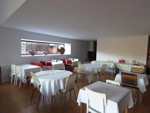 a restaurant with white tables and chairs and a window at Paco de Pombeiro - Turismo de Habitacao in Felgueiras