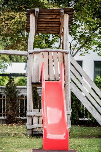 a red slide in front of a wooden chair at Hotel Sterzinger Moos in Vipiteno