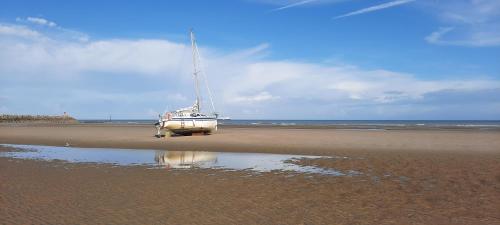 a boat is sitting on the sand on the beach at Maison Chez Lili à 200 m de la plage ,jardin privé et clos in Gravelines