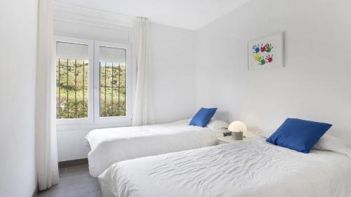 Duas camas num quarto branco com uma janela em I-51 - Calella de Palafrugell em Calella de Palafrugell