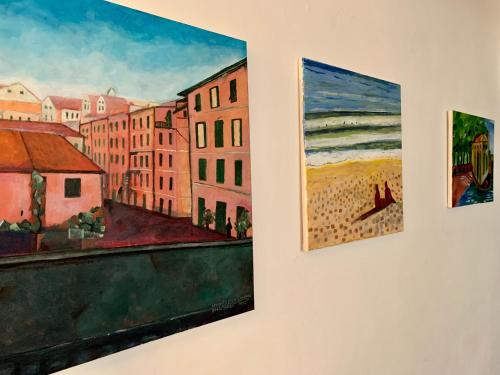 un grupo de pinturas colgando de una pared en Prince Apartment, en Levanto