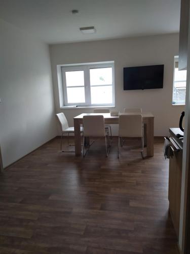 a room with a table and chairs and a flat screen tv at Ubytování na statku Račice in Račice