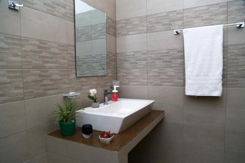 a bathroom with a white sink and a mirror at Chathu Holiday Home in Kandy