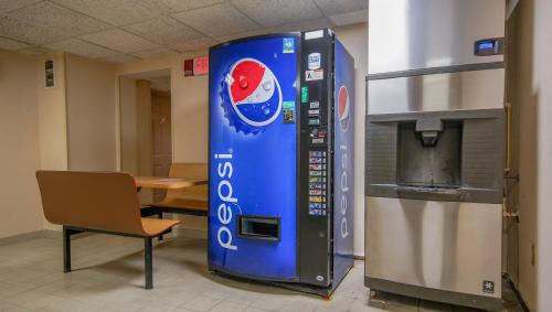 a pepsi machine in a room next to a chair at Americana Hotel Boardwalk in Ocean City