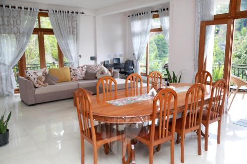 a living room with a wooden table and chairs at Chathu Holiday Home in Kandy