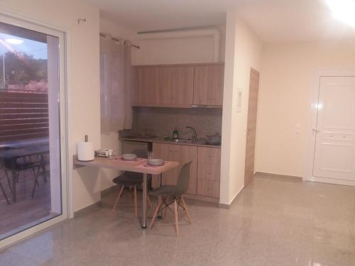 a kitchen with a table and chairs in a room at Nereids Apartments-Pronoe in Petalidhion