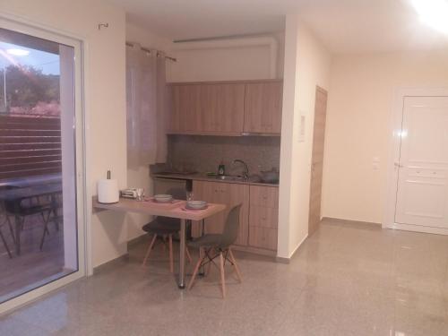 a kitchen with a table and chairs in a room at Nereids Apartments-Pronoe in Petalidi