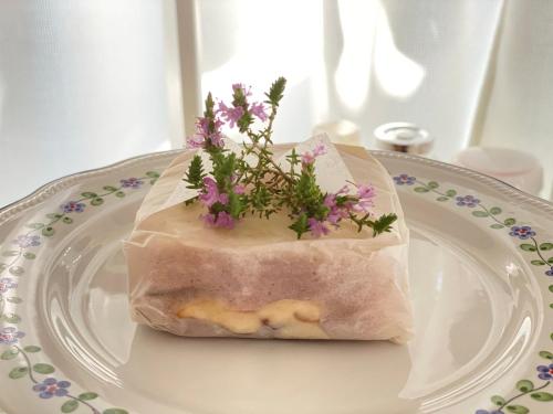 eine weiße Platte mit einem Paket mit Blumen darauf in der Unterkunft B&B Fellini Gallipoli in Gallipoli