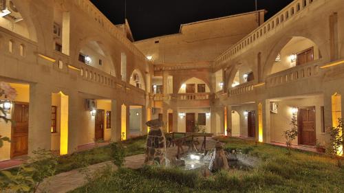 a large building with a courtyard at night at Dilek Kaya Hotel in Ortahisar