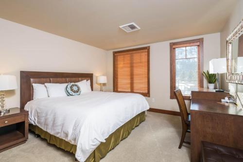 a bedroom with a large bed with a desk and a desk at Chilali 25 in Ketchum
