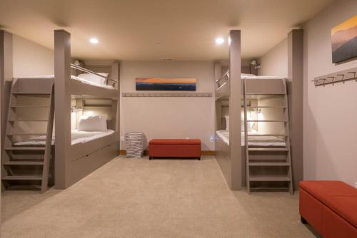a room with four bunk beds and a red couch at Chilali 25 in Ketchum