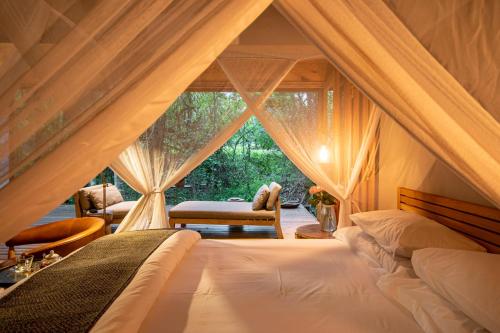 um quarto com uma cama e uma janela em Summerfields Rose Retreat and Spa em Hazyview
