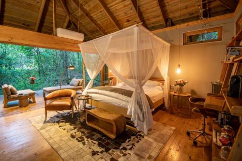 ein Schlafzimmer mit einem Himmelbett in einem Haus in der Unterkunft Summerfields Rose Retreat and Spa in Hazyview