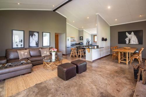 a living room with a couch and a table at Summerfields Rose Retreat and Spa in Hazyview