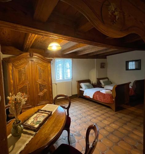 une chambre avec un lit et une table dans une pièce dans l'établissement La Ferme de Madeleine, à Fessenheim-le-Bas