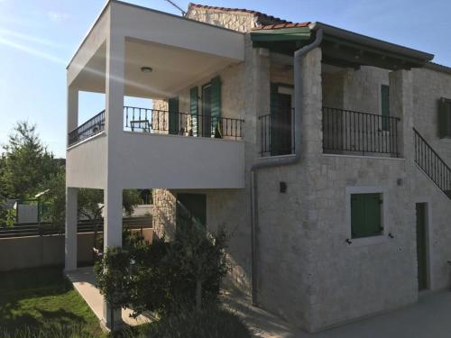 ein großes Steinhaus mit zwei Balkonen in der Unterkunft Corte villas & apartments - AE1043 in Privlaka