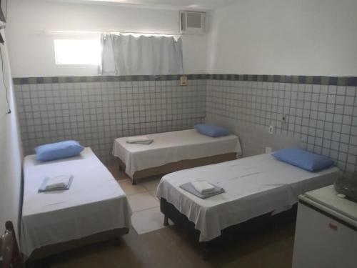 a hospital room with three beds and a window at Pousada Maré Mansa in Maceió
