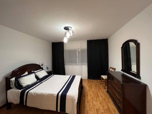 um quarto com uma cama, uma cómoda e um espelho em Atlantic view apartment at Formosa beach no Funchal