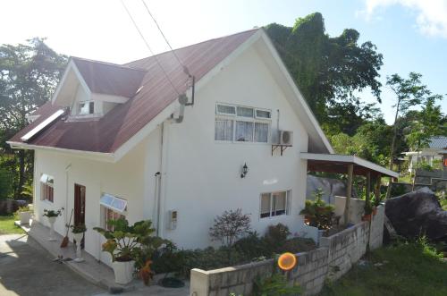 una casa blanca con techo rojo en Touchdown Villa, en Pointe Larue