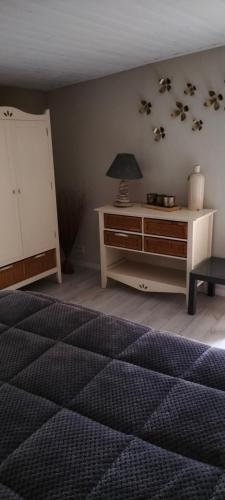 a bedroom with a bed and a table with a lamp at B&B Le verger in Échillais