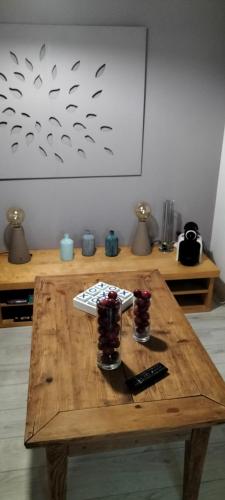 a wooden table with two glasses and a remote control at B&B Le verger in Échillais