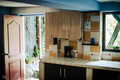 cocina con armarios de madera y encimera en Acogedor apartaestudio, en Armenia
