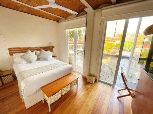 1 dormitorio con cama y ventana grande en Casa del Parque Hotel Boutique, en Cuernavaca