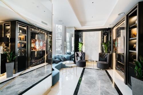 a living room with a blue couch and chairs at Merit Kensington Hotel in London