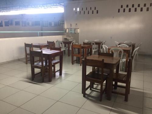 a group of tables and chairs in a restaurant at Pousada Maré Mansa in Maceió