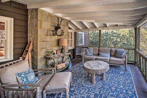 a screened in porch with a couch and a table at Mirror Lake Cabin about 1 Mi to Dtwn Highlands! in Highlands
