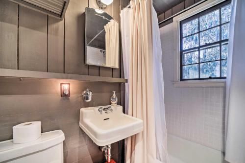a bathroom with a sink and a toilet and a window at Mirror Lake Cabin about 1 Mi to Dtwn Highlands! in Highlands