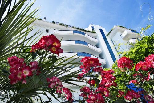 a white building with pink flowers in front of it at Residence Oltremare in San Benedetto del Tronto