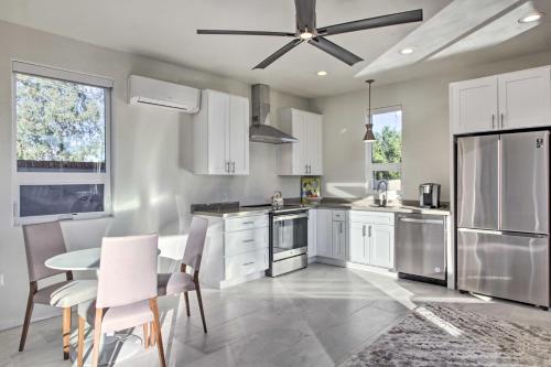 a kitchen with white cabinets and a table and chairs at Less Than 3 Mi to U of A Poolside Oasis in Tucson! in Tucson