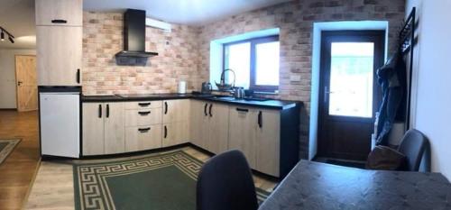 a kitchen with a table and a brick wall at Pod Śnieżnymi Kotłami in Piechowice