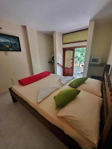 a bedroom with two beds with green and red pillows at Sam'S VIP Hostel San Gil in San Gil