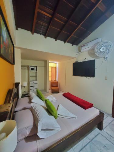 a bedroom with a large bed with green pillows at Sam'S VIP Hostel San Gil in San Gil