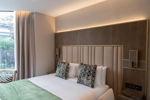 Ένα ή περισσότερα κρεβάτια σε δωμάτιο στο Merit Kensington Hotel