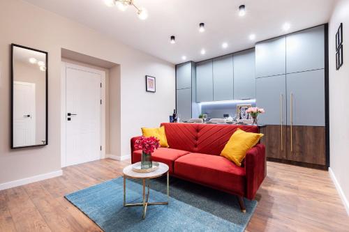 a living room with a red couch and a table at Lovely apartment Traku str. in Vilnius