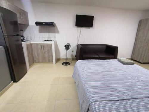 1 dormitorio con 1 cama, 1 silla y TV en Espectacular Loft Tipo Smart San Alonso, en Bucaramanga