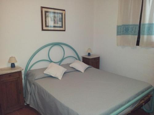 a small bedroom with a bed with two pillows at Villa Francesca in Flumini di Quartu