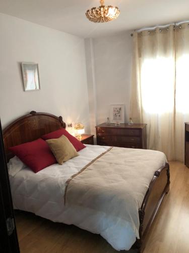 a bedroom with a bed and a chandelier at Apartamento Maracena Centro in Maracena