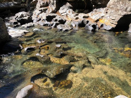 a pool of clear water with rocks and minerals at Ecopousada Toca do Guará in Alto Paraíso de Goiás