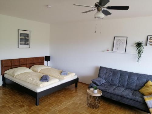 a living room with a bed and a couch at Sonnige Ferienwohnung mit Seeblick in Uhldingen-Mühlhofen
