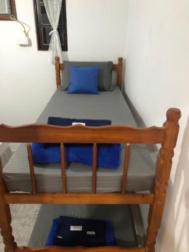 a bunk bed in a room with a blue pillow at Casa Vila Mar - Inn Prainha in Arraial do Cabo
