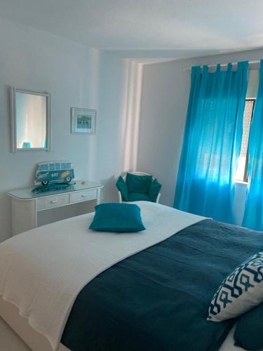 una camera da letto con un grande letto con tende blu di CASA UNIÃO Carvoeiro a Carvoeiro