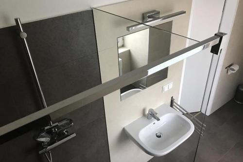 a bathroom with a sink and a mirror at Motel Graz Ost I Free Parking I Self Check-in in Graz