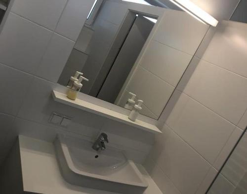 a bathroom with a sink and a mirror at Motel Graz Ost I Free Parking I Self Check-in in Graz